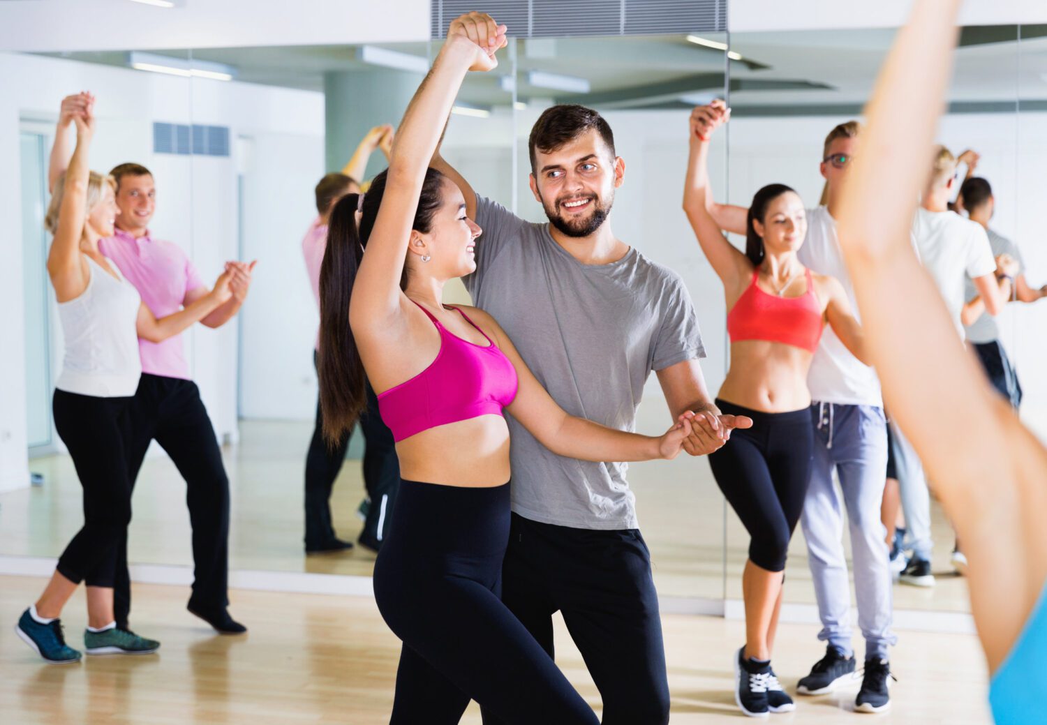 Group of young adults dancing salsa in club